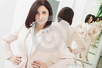 Portrait Of A Dark Haired Attractive Woman Who Is Dressed In Beige Suit