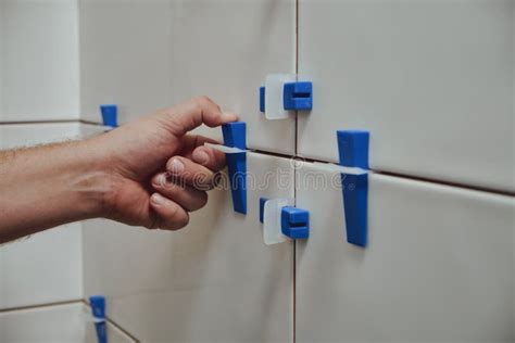 Tiler Using Tile Leveling System When Laying Ceramic Tiles On Bathroom