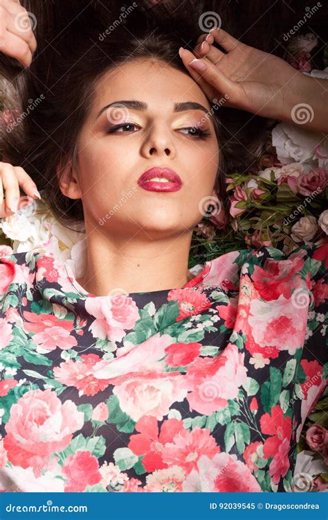 Portrait Of Beautiful Sensual Woman Lying Down On Flowers Stock Image