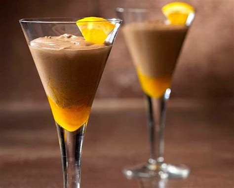 Two Martini Glasses Filled With Liquid And Topped With An Orange Slice