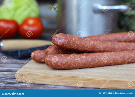 Red German Ham Sausages On Wooden Plate Arranged With Knife And