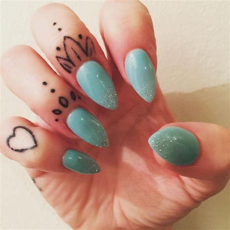 A Woman S Hand With Some Blue And Green Nail Polishes On Her Nails