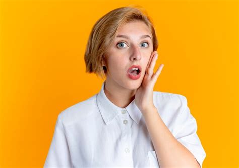 Jeune Fille Russe Blonde Surprise Met La Main Sur Le Visage Isolé Sur Fond Orange Avec Copie