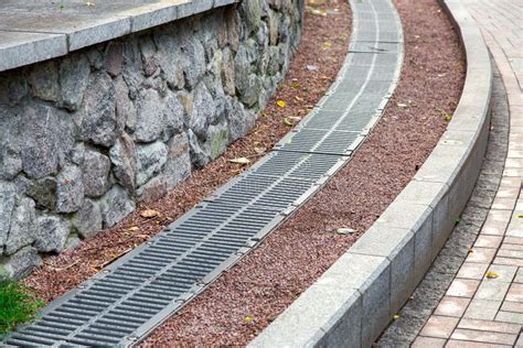 Grille Of The Drainage System Manhole On The Curve Pedestrian Sidewalk