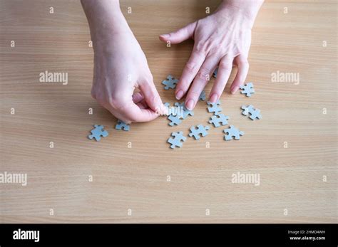 Hands Arranging Puzzle Pieces On Table Stock Photo Alamy