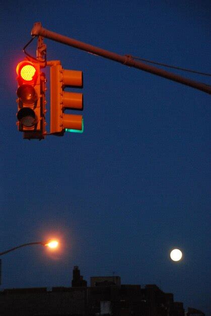 Um semáforo vermelho uma lua cheia ao fundo Foto Premium