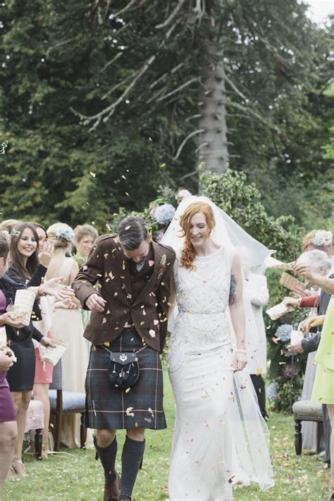 A Bride And Groom Walk Down The Aisle As Confetti Is Thrown Around Them