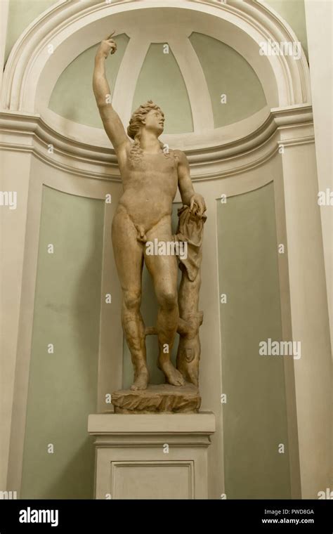 A Marble Statue Of A Naked Male Angel In An Alcove On Display In The