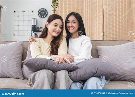 Young Lgbt Woman Lesbian Couple Sitting On The Sofa Hugging And