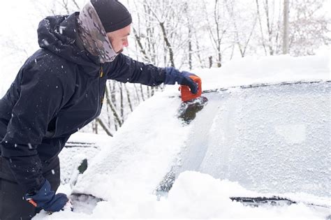 Premium Photo Man Cleans His Car After A Snowfall Cleaning Snow From