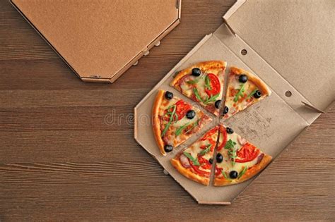 Cardboard Box With Tasty Pizza On Wooden Background Top View Stock