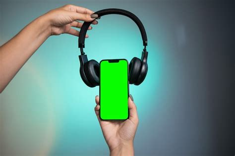 Premium Photo | Modern headphone and gadget with green screen. black headphones on phone