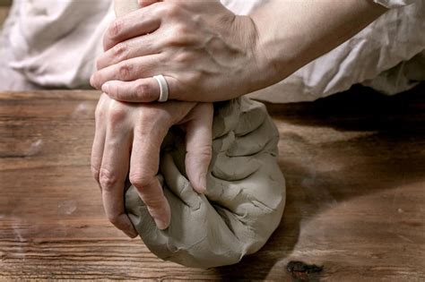 Premium Photo Kneading Piece Of Raw Grey Clay By Female Hands On