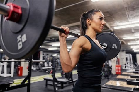 Premium Photo A Strong Woman Is Doing Exercises With Barbell In A Gym