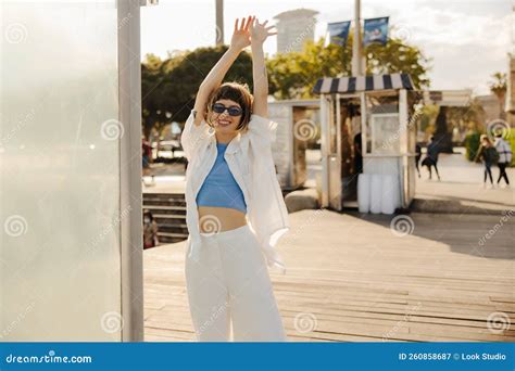 Positive Young Caucasian Girl Stretches Her Arms Above Head Relaxing