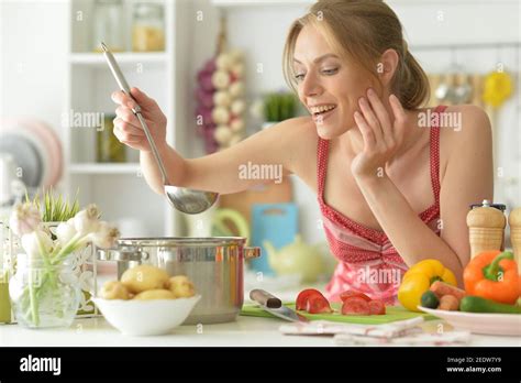Beautiful Young Woman Cooking Soup In Kitchen Stock Photo Alamy