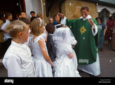 St Josephs Church Roehampton Children And Priest Arms Outstretched Stock