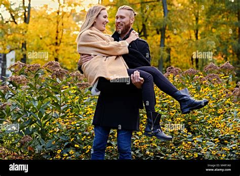 Redhead Bearded Male Holds In His Arms Cute Blonde Female In An Autumn