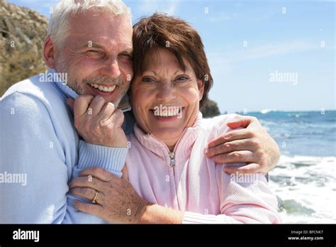 Mature Couple Hugging By The Oceanside Stock Photo Alamy