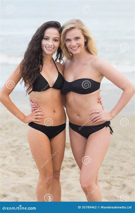 Mujeres Jovenes Sonrientes Del Bikini En La Playa Foto De Archivo