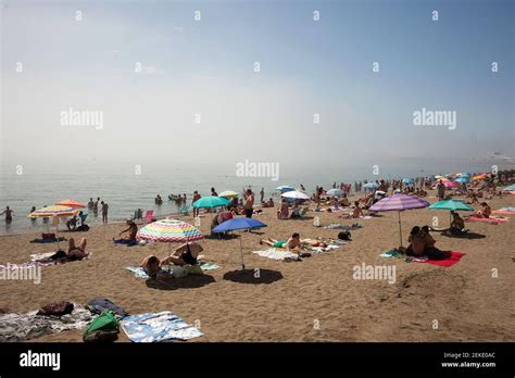 Se ve a la gente tomando sol en la playa de Malagueta en un día de