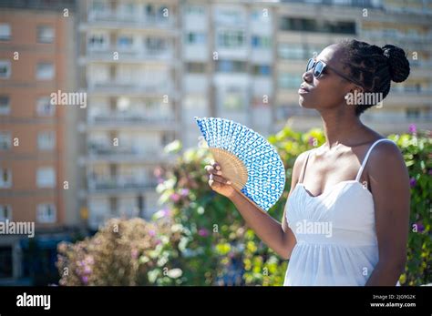 Woman Fanning Herself On A Hot Day Blurred City View Background Stock Photo Alamy