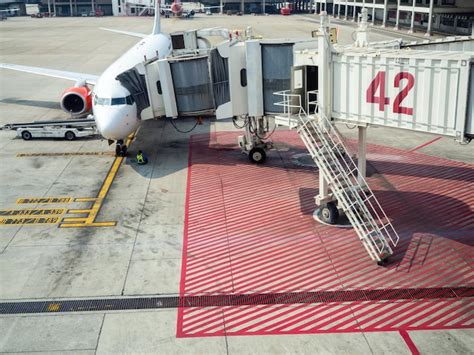 Avião de passageiros moderno estacionado no portão do edifício terminal