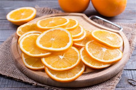 Rodajas De Naranja Fresca Sobre Una Tabla Para Cortar Foto Premium