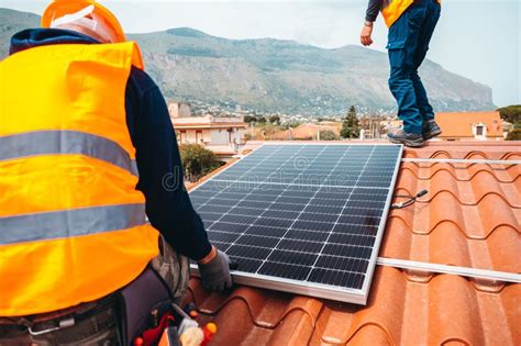 Workers Assemble Energy System With Solar Panel For Electricity And Hot Water Stock Image