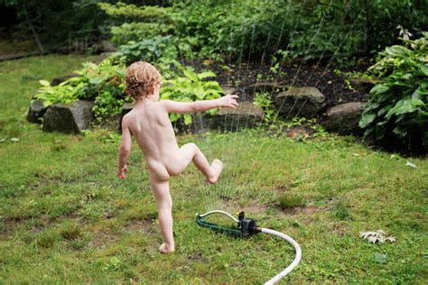 Naked Boy Playing With Sprinkler Stock Photo Dissolve