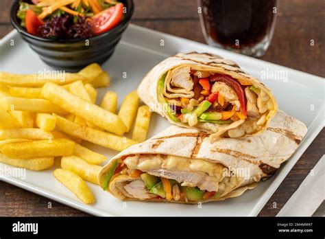 Chicken Wrap With French Fries And Salad Stock Photo Alamy