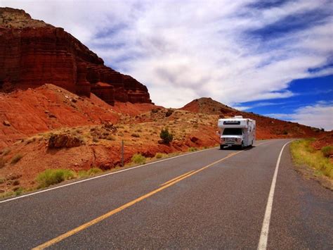 Premium Photo Car Moving On Road By Mountain Against Cloudy Sky