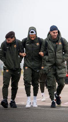 Three Men In Green Jackets And White Socks Are Walking On An Airport