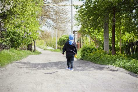 deambular solo por una calle rural un niño pequeño está caminando por