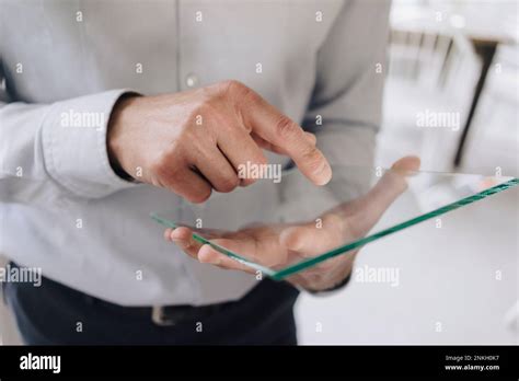 Mature Businessman Using Futuristic Transparent Tablet PC In Cafe Stock