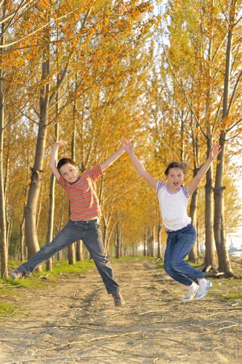 Los Niños Que Saltan En Bosque Foto De Archivo Imagen De Hierba