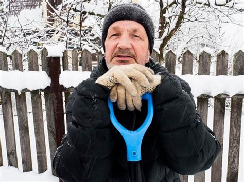 Premium Photo Senior Man Sitting By Fence During Winter
