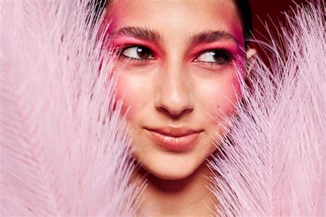 premium photo beauty fashion female pink feathers pink face makeup
