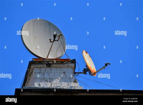 Satellite Dish Antennas On The Building Roof On Blue Sky Modern