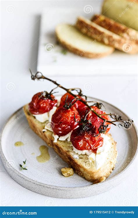 Tomato Confit And Goat Cheese Bruschetta On Grey Concrete Table Stock