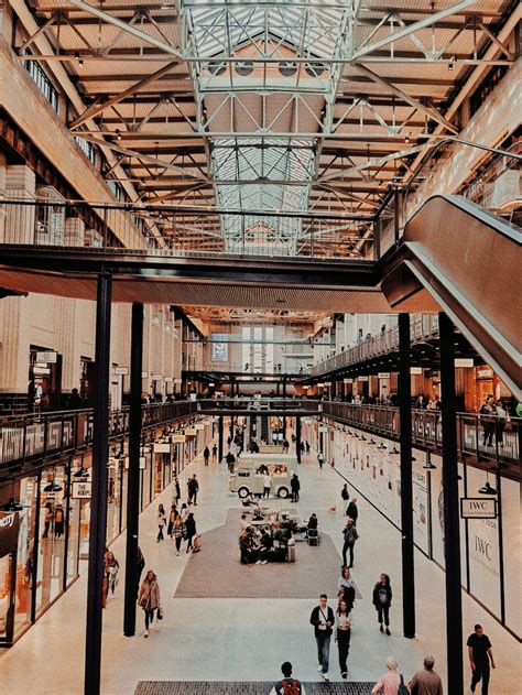 A Group Of People Walking Around Inside Of A Building Photo Free