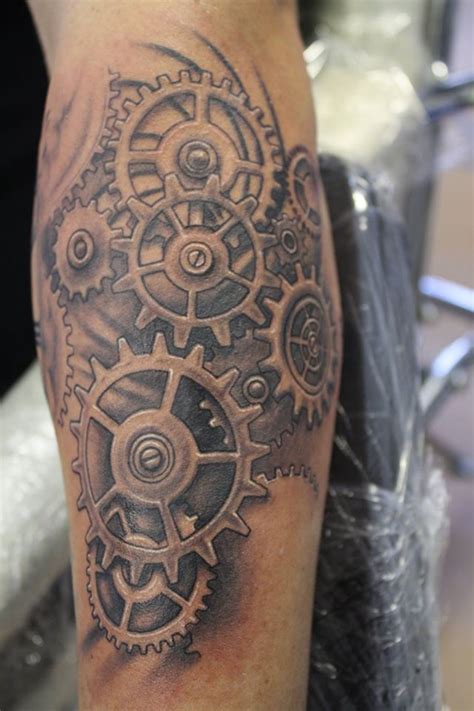 a man with a tattoo on his leg that has gears and cogs all over it