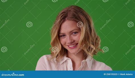 Attractive Female With Short Blonde Hair Smiling At Camera On Green