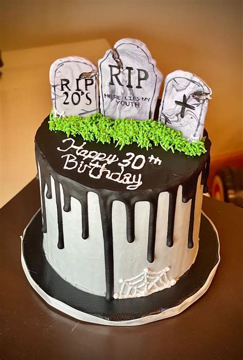 A Birthday Cake Decorated With Tombstones And Green Grass For The Top