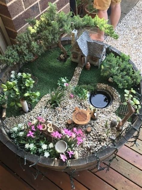 A Potted Planter Filled With Lots Of Plants And Small Houses On Top Of It