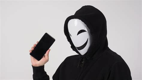 Hacker anônimo e máscara facial smartphone à disposição Foto Premium