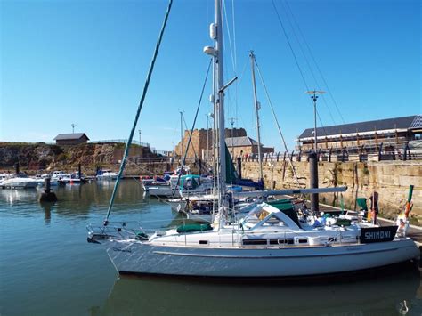 A Sailboat Is Docked In The Harbor