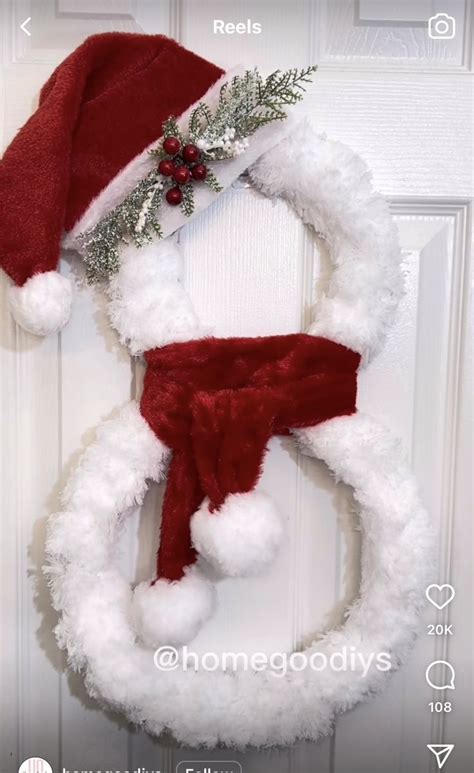 A Christmas Wreath With A Santa Hat Hanging On The Front Door And An