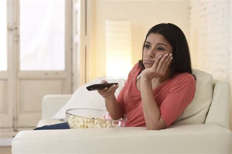 Young Beautiful Woman At Home Watching Television Tired And Bored Stock