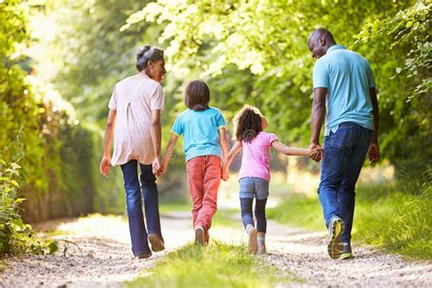 Grands Parents Avec Des Petits Enfants Marchant Par La Campagne Photo